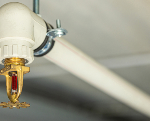 Close Up Image Of Fire Sprinkler With Fire In Background