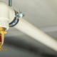 Close Up Image Of Fire Sprinkler With Fire In Background